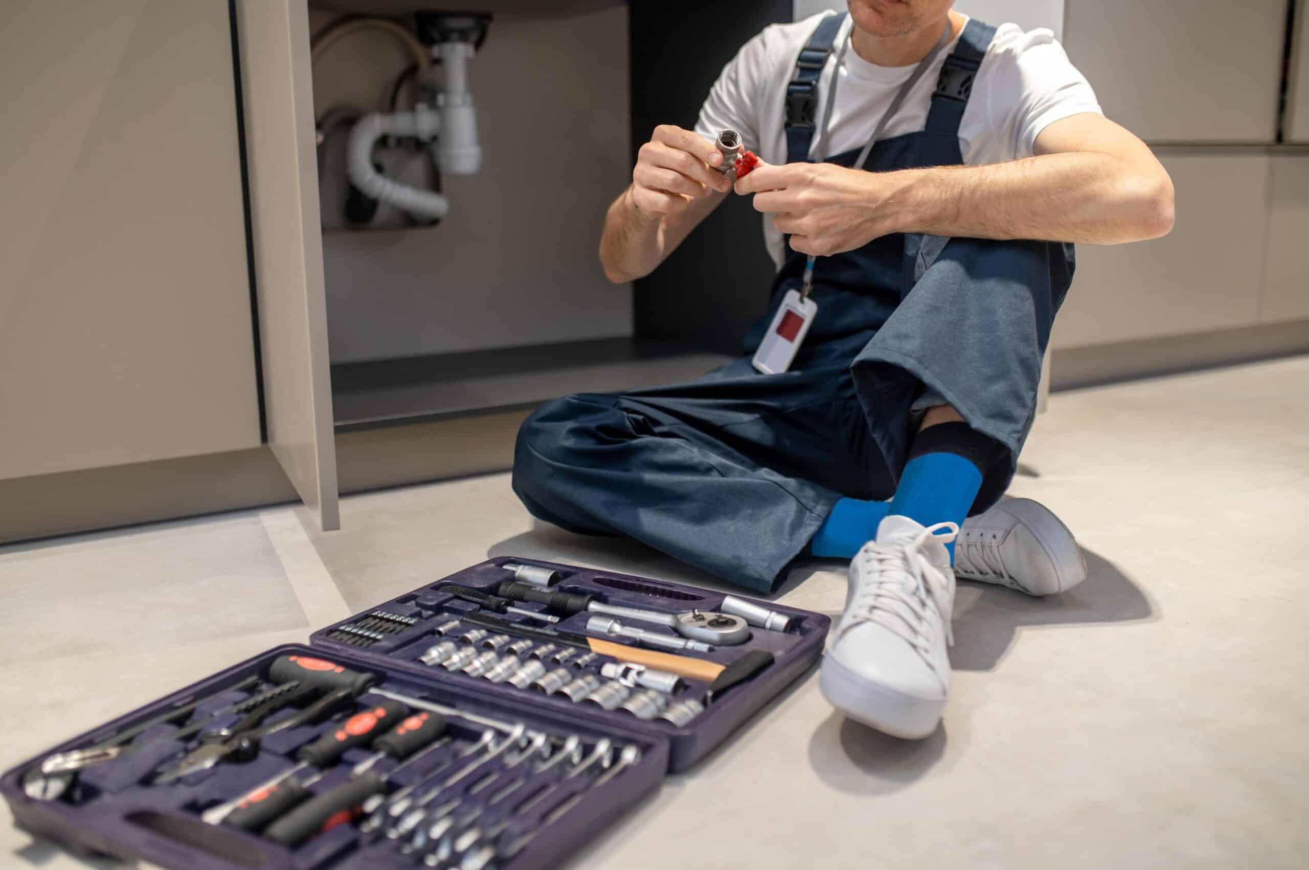 homme assis avec une mallette à outils